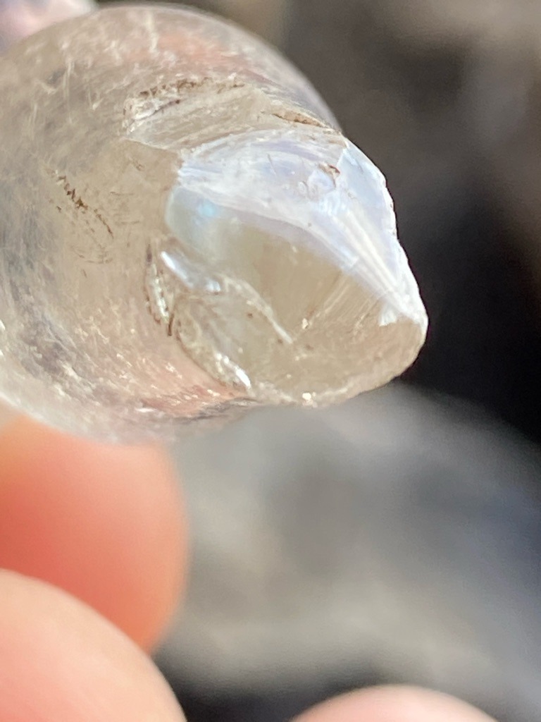 The image shows a raw, rough crystalline mineral specimen, likely quartz or a similar rough gemstone rather than a cut diamond. - Rough, unpolished crystal form with natural termination