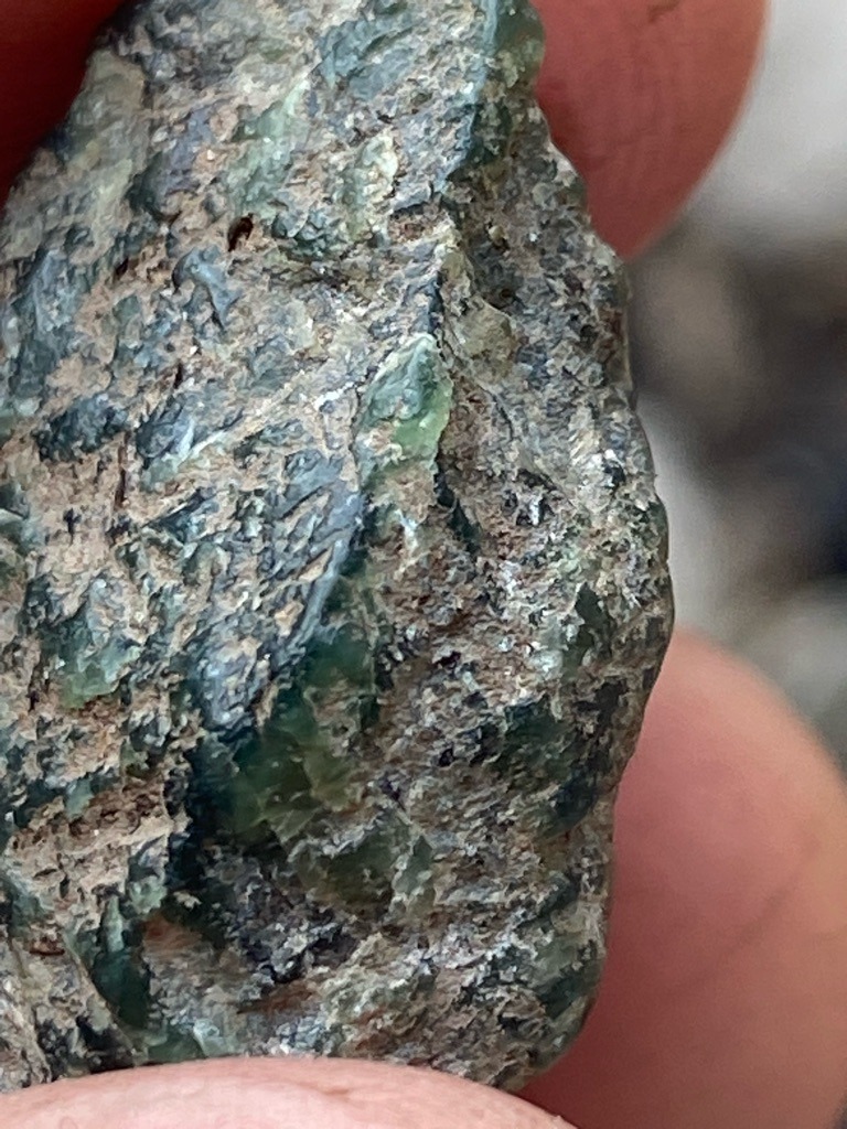 Not a diamond; this is a rough green mineral matrix, likely containing olivine, serpentine, or peridot, commonly found in a metamorphic or ultramafic host rock. - Rough crystal matrix, uncut and unshaped.