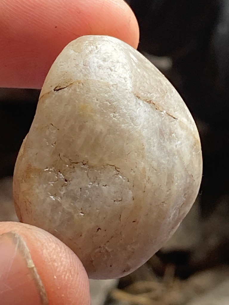 Not a diamond; this specimen appears to be an alluvial quartz or quartzite pebble, potentially quartz or chalcedony, displaying natural water-worn characteristics rather than crystalline diamond structure. - Irregular tumbled / water-worn pebble shape (non-faceted)