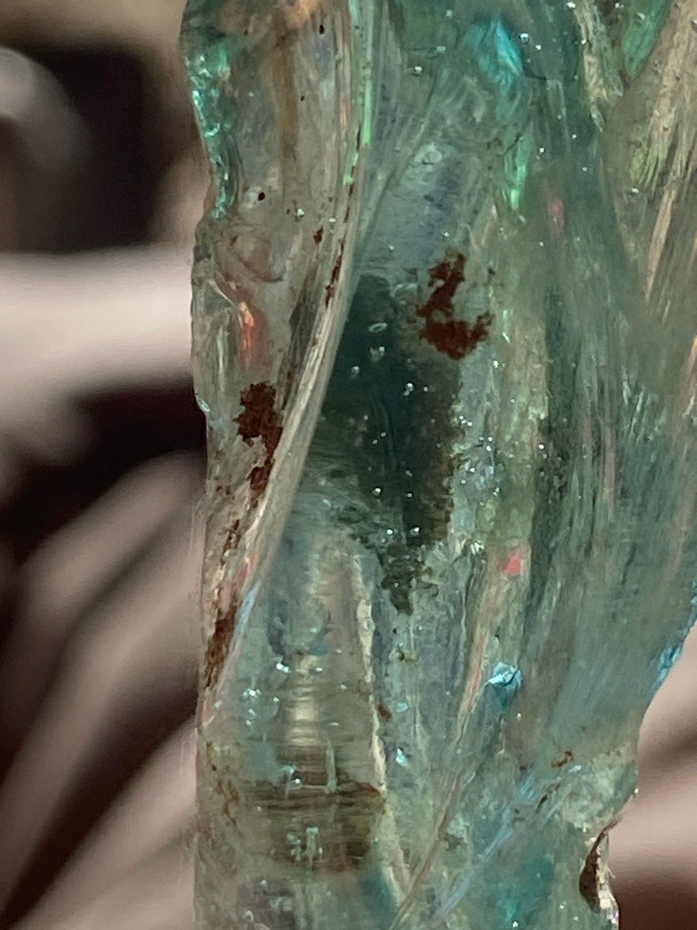 Not a diamond; this specimen appears to be raw quartz, glass slag, or rough aquamarine crystal matrix with iron oxide staining and numerous gas bubbles/inclusions. - Raw, uncut, or natural crystal form with irregular shaping.