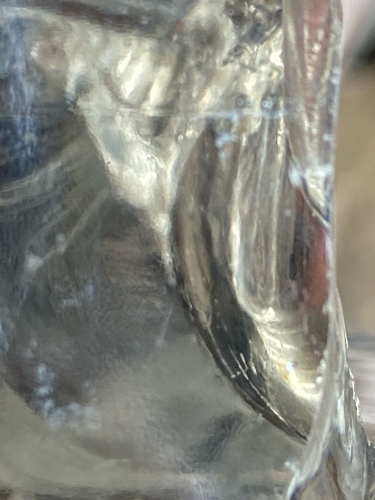 Unable to definitively determine gemstone type from the provided close-up texture image; appears to be a distorted or magnified view of a crystalline or resinous material rather than a traditional faceted diamond. - Not applicable / Irregular