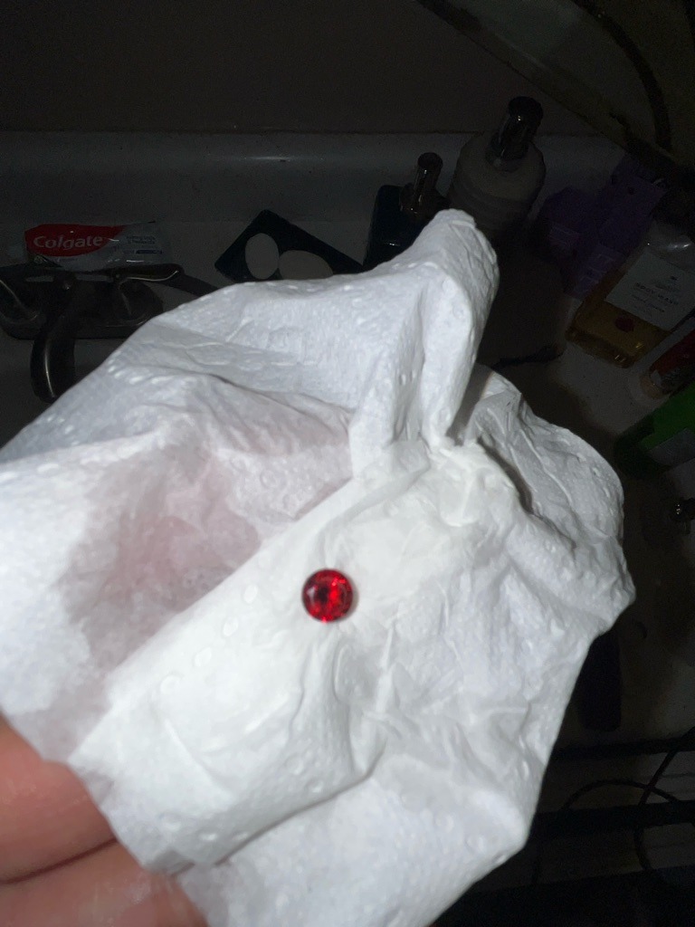 Not a diamond; this gemstone appears to be a ruby or a red-colored synthetic simulant (such as cubic zirconia or glass) due to its vibrant red coloration, as natural diamonds do not typically occur in this shade of saturated red without intense fancy color grading (and even then, genuine red diamonds are extremely rare). - Round Brilliant