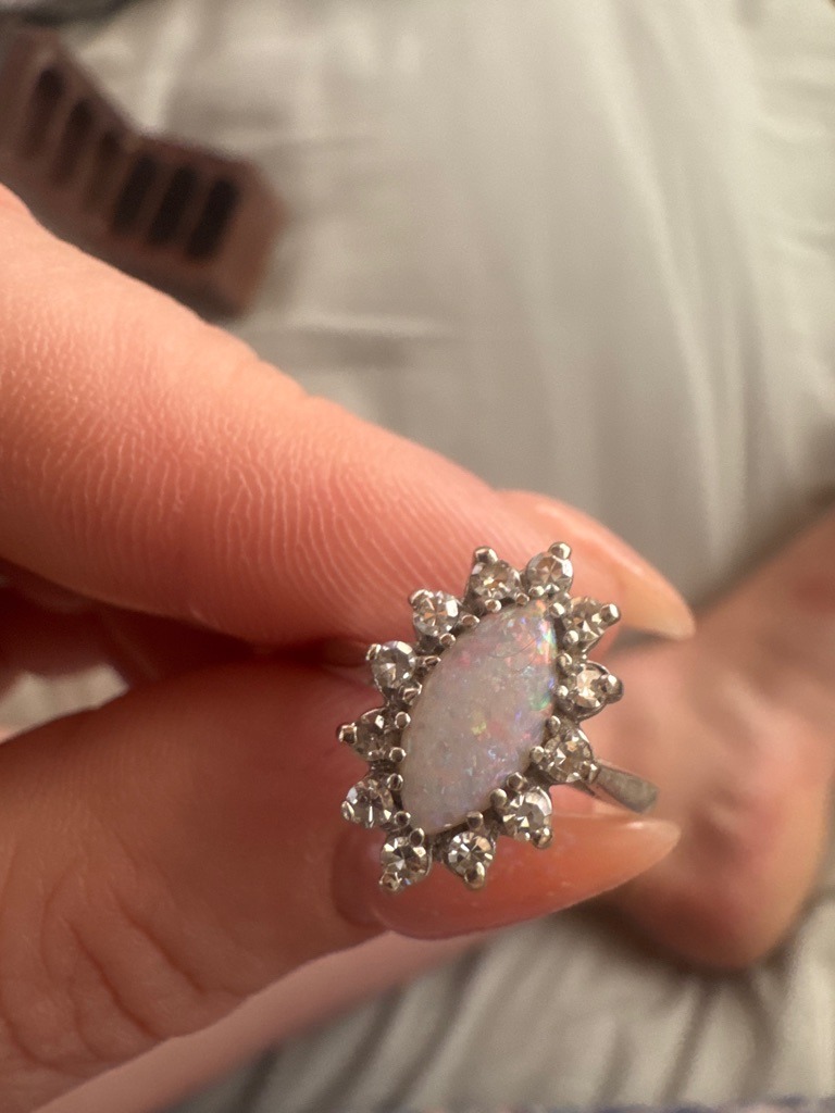 Natural (The center stone is a White Opal, surrounded by what appear to be natural diamond or white gemstone accents) - Marquise (Center), Round Brilliant (Accents)