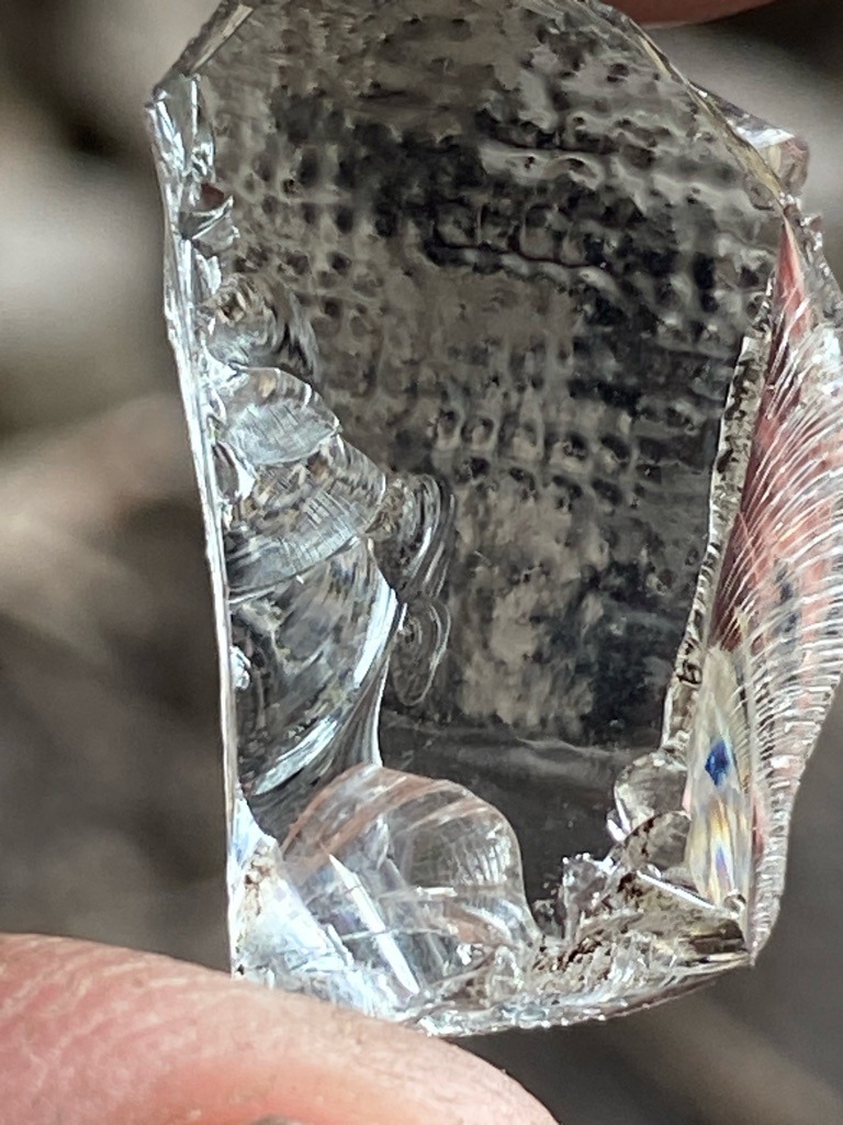 Natural rough mineral crystal (likely quartz, glass, or rough gemstone rather than a gem-quality diamond based on the conchoidal fracture patterns and lack of crystal faces) - Uncut rough mineral fragment with irregular, conchoidal fracture