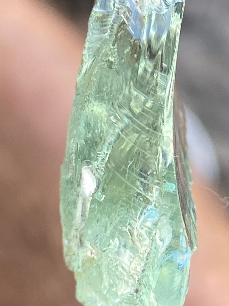 Not a diamond; this specimen appears to be green glass or slag, displaying conchoidal fracture and flow lines characteristic of amorphous materials rather than crystalline diamond. - Rough / Ungraded, irregular fracture piece