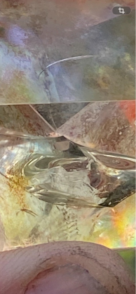 The provided image displays a complex, close-up macro view, making it inconclusive for standard diamond typing without specialist instruments like a Raman spectrometer, though visually it exhibits strong refraction typical of crystalline materials. - Irregular or raw crystal fragment / faceted art piece, not conforming to a standard commercial cut shape.