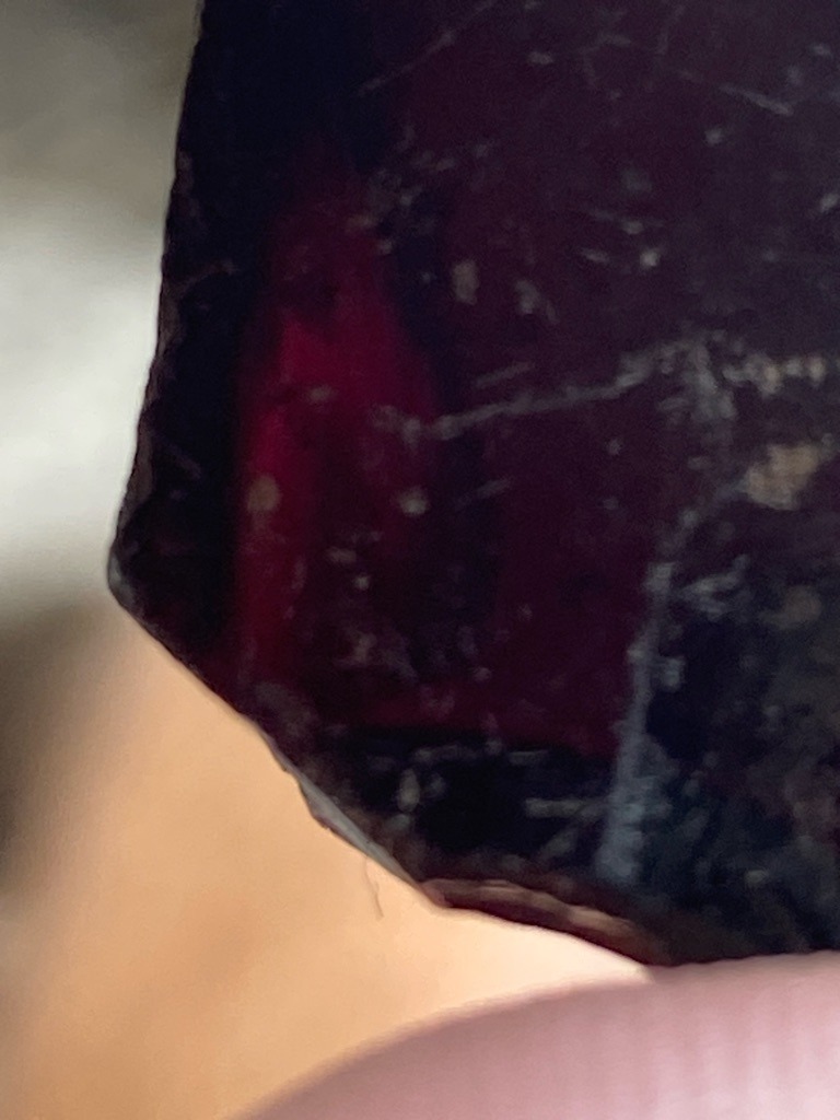 Not a diamond; rough crystalline gemstone material, possibly garnet or tourmaline based on color and texture - Uncut rough crystal fragment