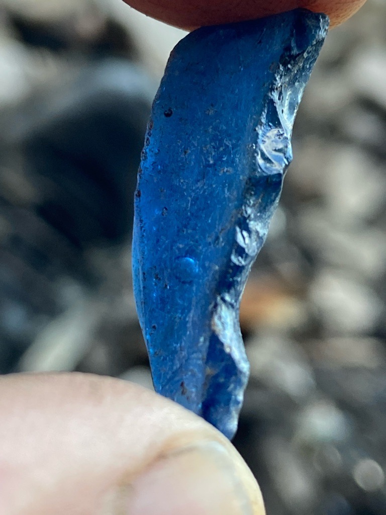 Not a diamond; visual indicators (conchoidal fracture, bubble-like inclusions, deep blue color) suggest this is man-made cobalt-colored glass or slag, sometimes referred to as 'sea glass' or industrial cullet. - Rough irregular shard / fragment