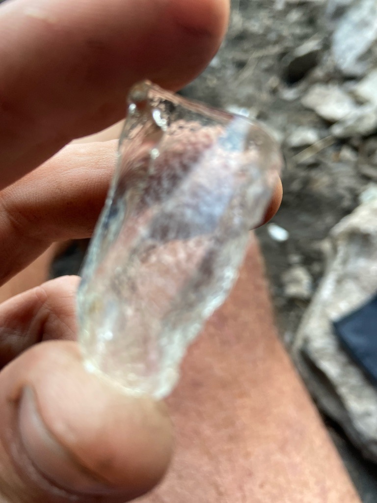 The image shows a raw, uncut mineral specimen, likely quartz or glass rather than a genuine gem-quality rough diamond. - Rough crystal form, untutored and unpolished nugget shape.