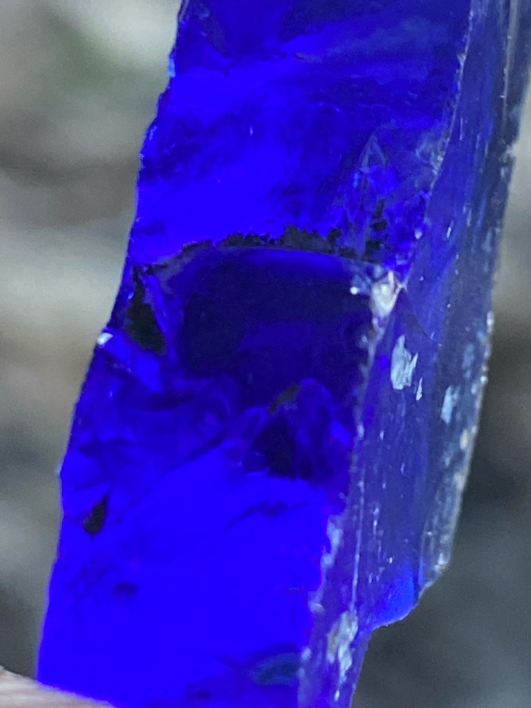 Not a diamond; this specimen appears to be cobalt blue glass or synthetic slag, displaying conchoidal fracture patterns characteristic of glass rather than crystalline diamond or gemstone rough. - Rough uncut specimen with conchoidal fractures, unpolished and irregular.