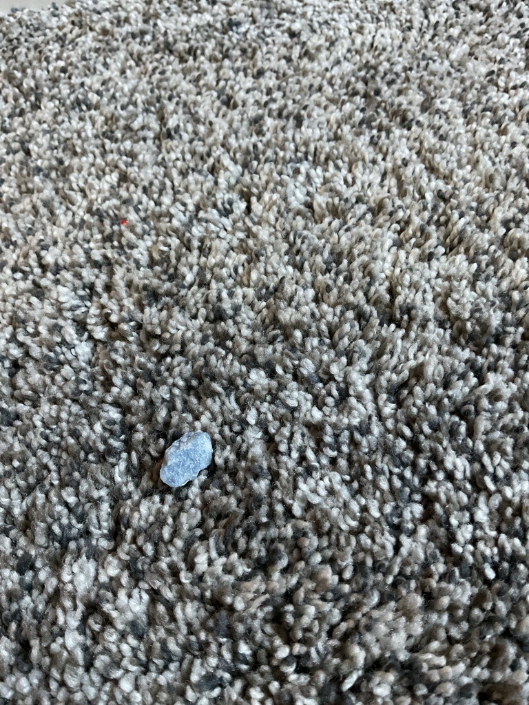 The object in the image is not a diamond; it appears to be a common igneous or metamorphic rock fragment or a piece of gravel/pebble. - Rough, irregular, and un-cut (Freeform).