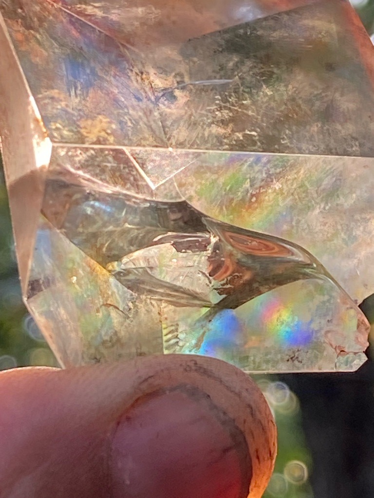 Not a diamond; this appears to be an optical glass prism or coated quartz crystal displaying internal reflections and thin-film interference colors. - Irregular multifaceted block / prism