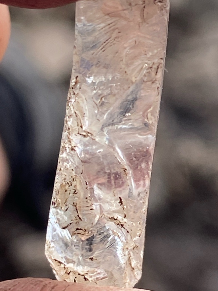 Rough natural diamond crystal (or possibly high-quality quartz crystal/specimen given the conchoidal fracture patterns and brownish matrix inclusions, but assuming gem-grade diamond crystal context) - Rough elongated crystal / Raw octahedral or distorted crystal form
