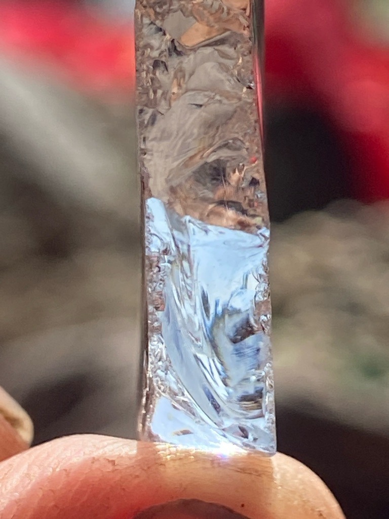 Rough diamond crystal, likely natural uncut specimen showing characteristic surface features such as trigons or striations. - Rough crystal / Uncut octahedral or elongated crystal habit