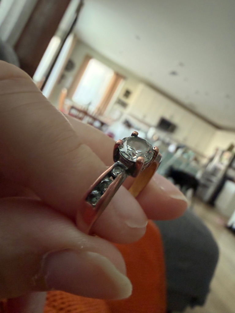 Natural Diamond (Assessed visually, high refractive index and dispersion consistent with diamond or high-quality simulant, likely natural based on typical ring style) - Round Brilliant