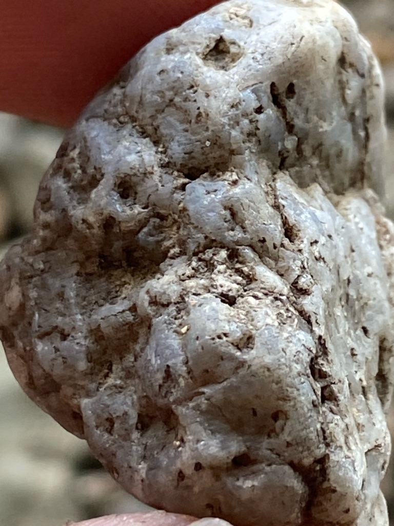 Natural rough stone, highly likely to be quartz/chalcedony or potentially unpolished rough diamond crystal matrix, but visually consistent with an alluvial rough quartz pebble given the weathered matrix and lack of octahedral crystal faces. - Rough, uncut, natural pebble form (unshaped/raw)
