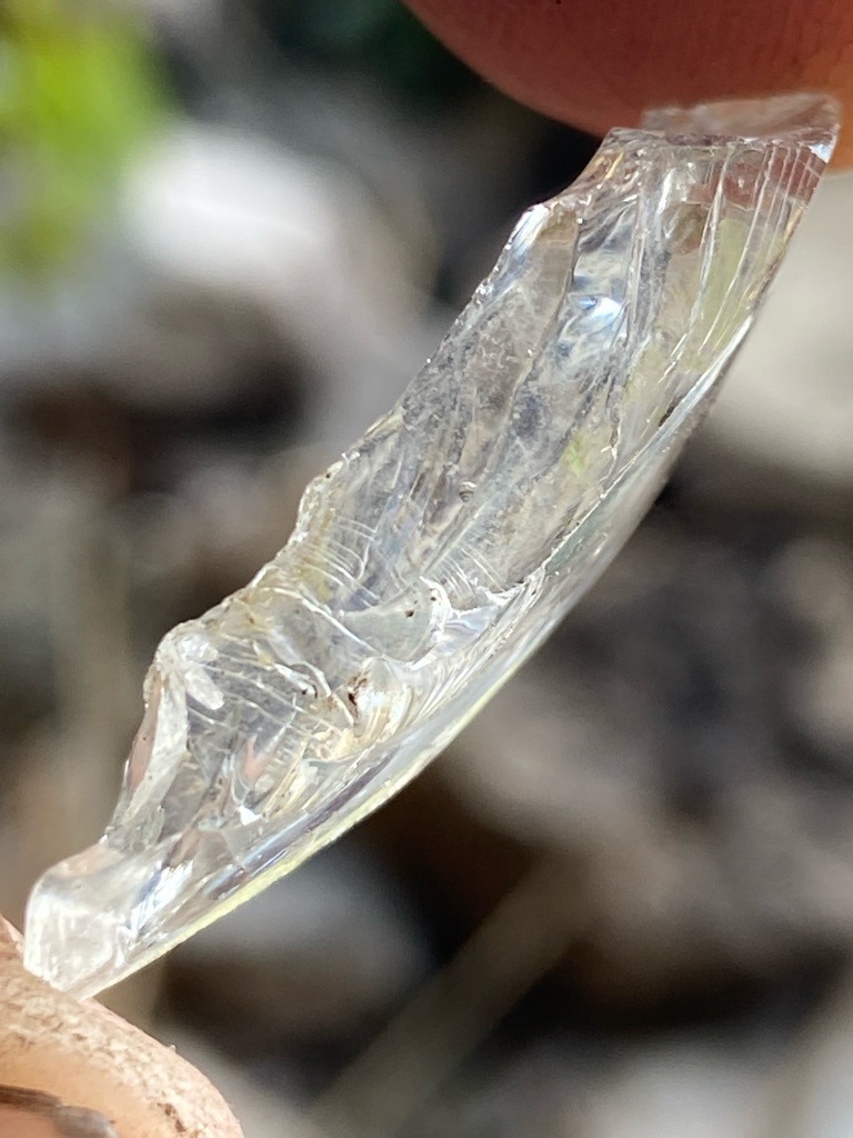 Not a diamond (likely quartz, glass, or mineral crystal fragment based on conchoidal fracture and growth lines) - Raw crystal fragment / Irregular shard
