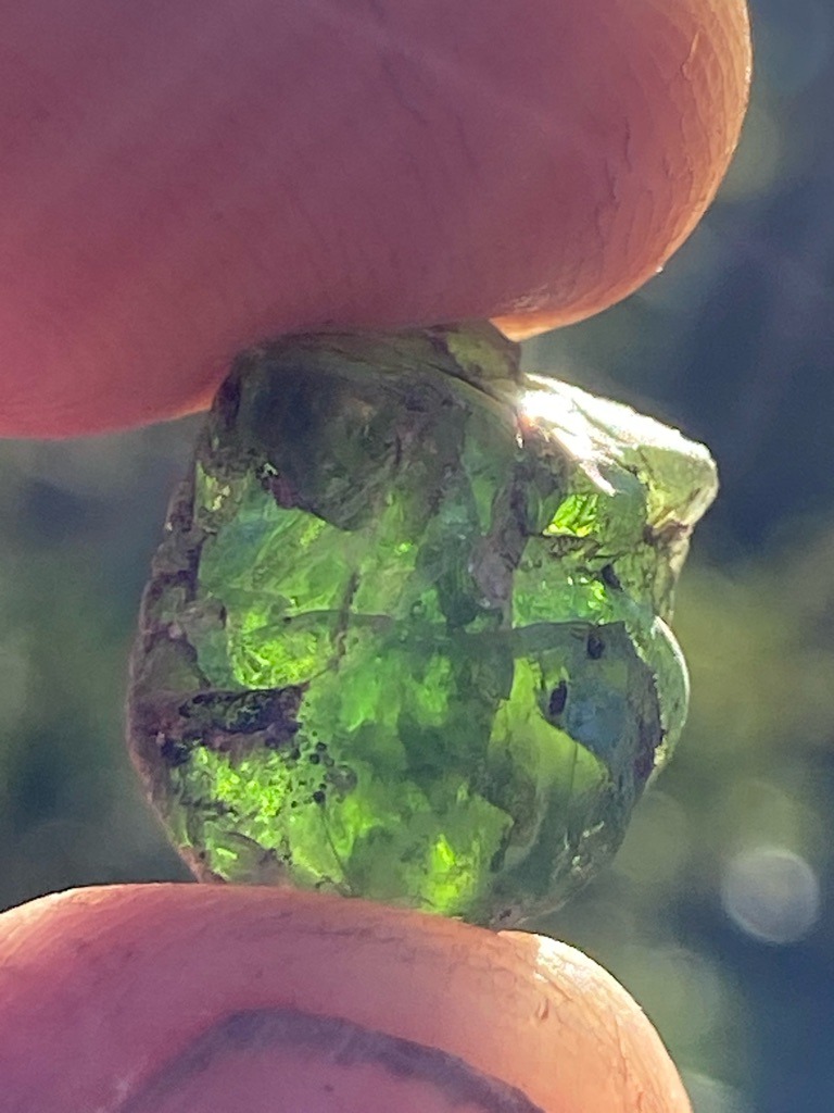 Not a diamond; this is a rough green gemstone, likely Peridot or rough Green Tourmaline, displaying natural crystalline structure and inclusions. - Rough uncut crystal, irregular pebble form with natural faces and fractures.