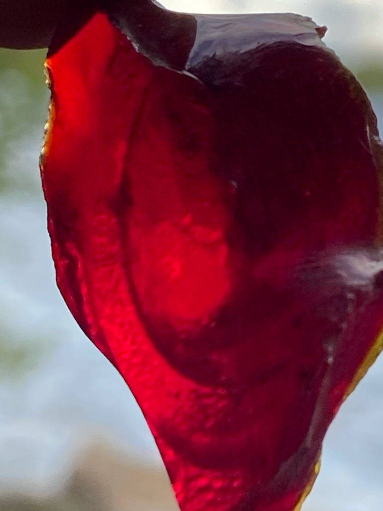 Natural Carbonado or heavily included diamond slice with intense red-to-brownish irradiation coloring, though visually resembles a sliced natural rough crystal or translucent mineral aggregate. - Irregular Slice / Rough Crystal