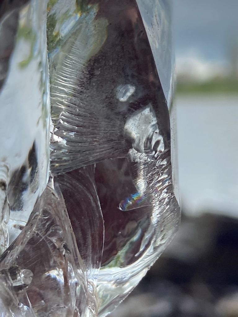Not a diamond; this is a piece of transparent glass or quartz showing conchoidal fracture and stress striations. - Irregular / Raw fragment