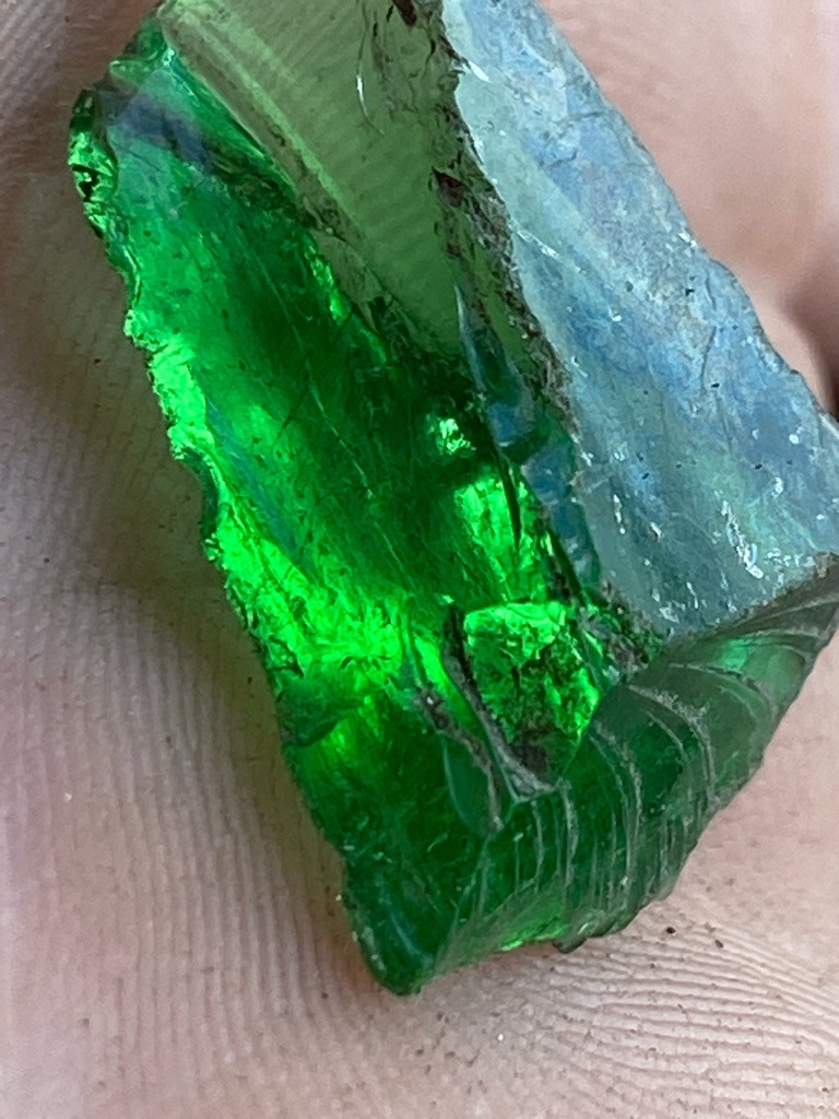 Not a diamond; this is a piece of green glass or slag, displaying conchoidal fracture typical of amorphous materials rather than crystalline diamond structure. - Raw, unpolished, irregularly fractured fragment (rough/slag)