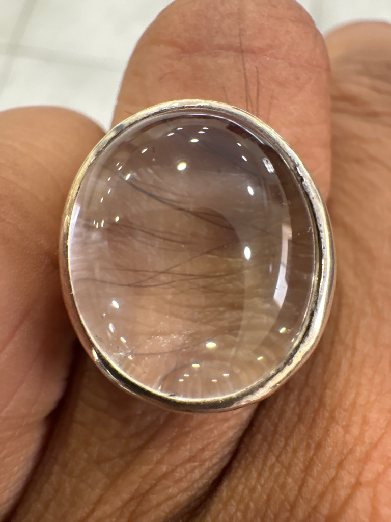 Unknown / Likely Not Diamond (Visual identification suggests Rutilated Quartz or highly included Quartz) - Oval Cabochon