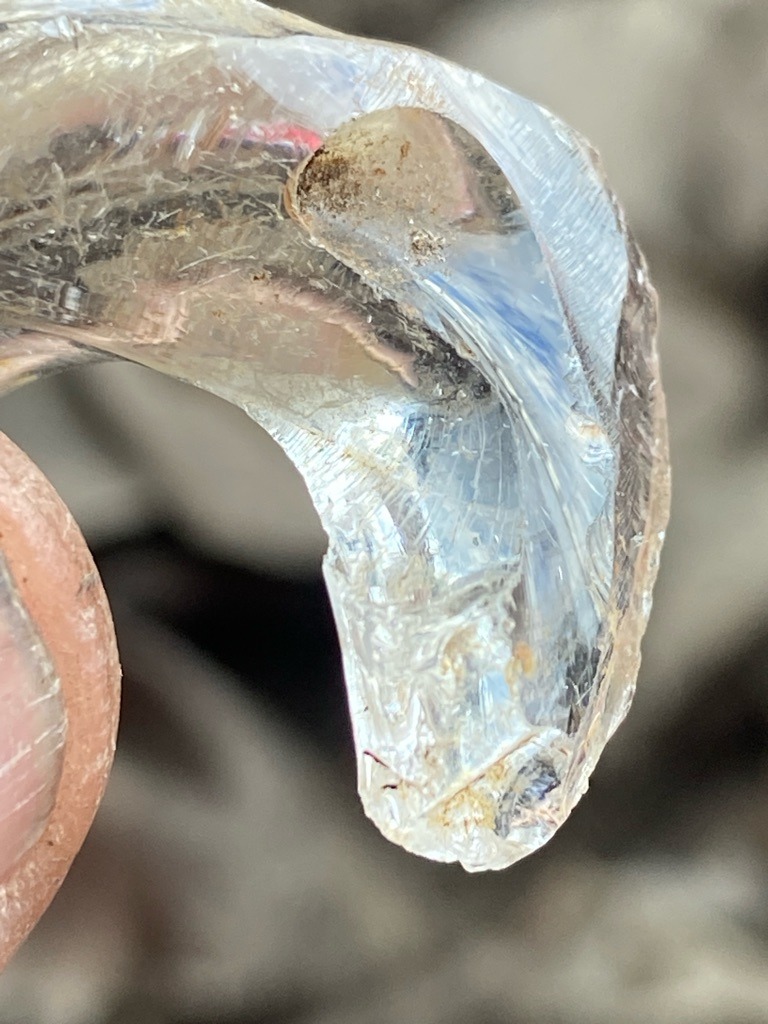The image does not show a diamond; rather, it appears to display a fragment of transparent or translucent industrial glass or quartz with conchoidal fracture patterns. - Irregular raw fragment, not a faceted diamond shape.