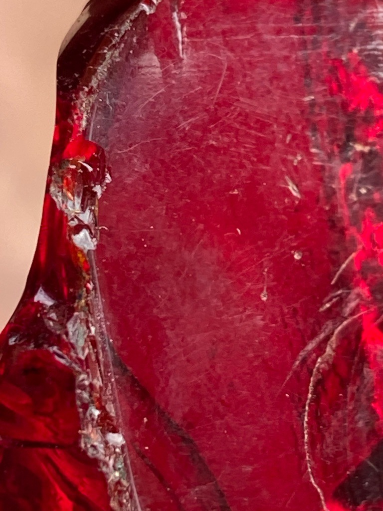 Not a diamond; this specimen appears to be coloured glass or a heavily included rough mineral material with conchoidal fracturing. - Irregular rough, untutored fragment
