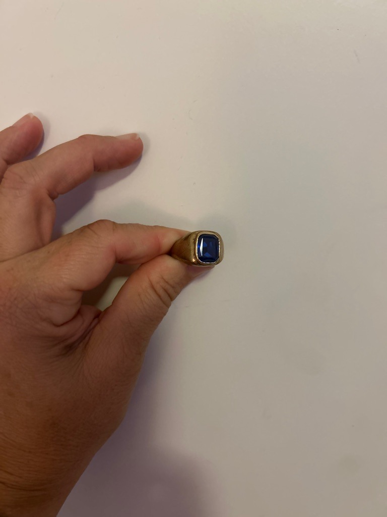 Not a diamond; this gemstone appears to be a natural or synthetic blue sapphire or spinel set in a yellow gold ring. - Cushion or emerald cut with rounded corners