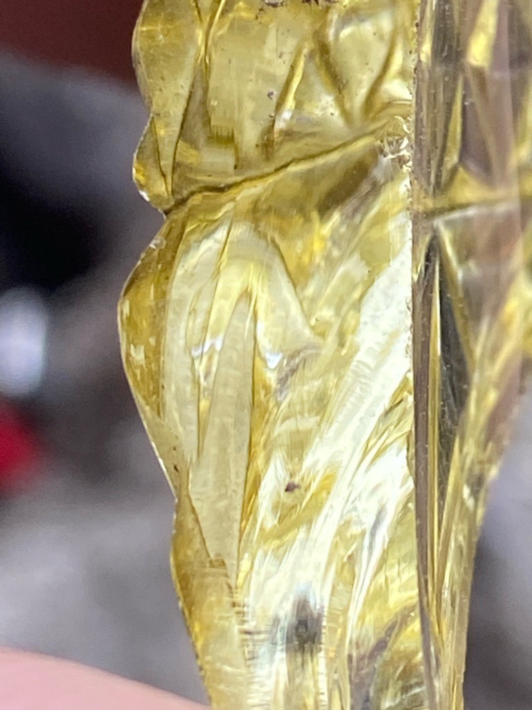 Not a diamond; appears to be raw or carved yellow amber, resin, or possibly a yellow glass/slag material due to the conchoidal fracture patterns, organic texture, and lack of diamond crystal habit. - Irregular raw or carved form, not a standard faceted diamond cut