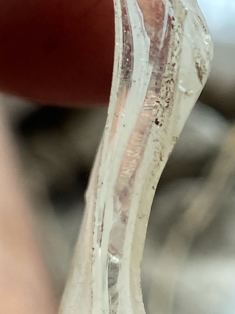 Not a diamond; appears to be industrial glass, quartz, or a synthetic silicate material with fracture-filled structures and significant surface wear. - Irregular / Raw fragment shard