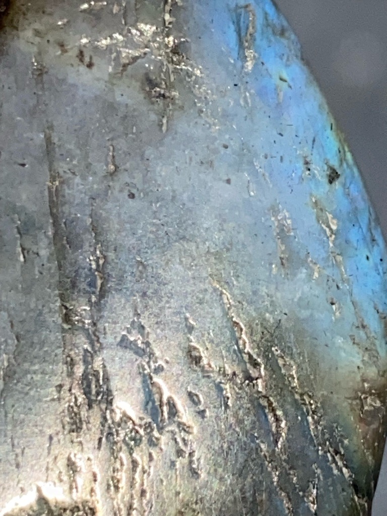 Not a diamond; this is a mineral, specifically Labradorite (feldspar) showing labradorescence. - Irregular / Cabochon or rough slab structure, not faceted.