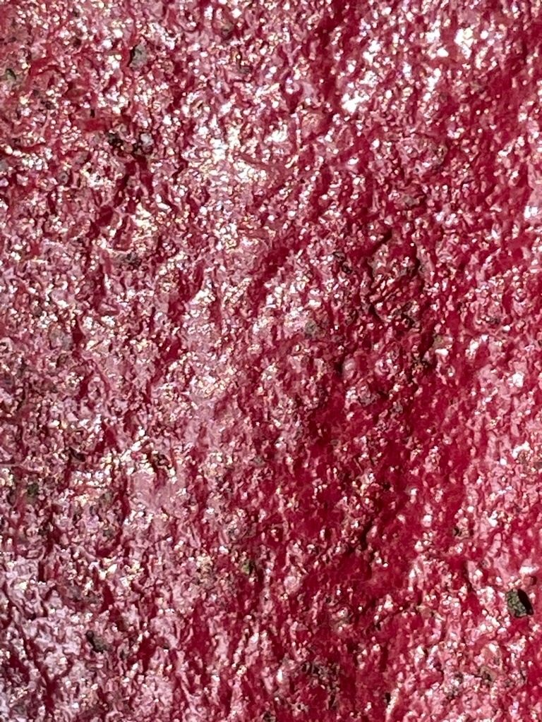 Not a diamond; this image displays a textured, glittery, or metallic reddish surface resembling painted stucco or a synthetic craft texture rather than a crystalline diamond structure. - Not applicable