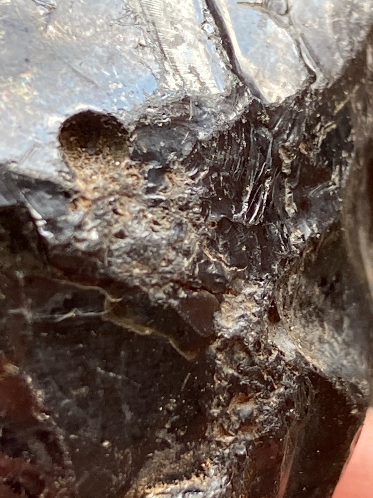 Not a diamond; appears to be raw matrix, slag, dark mineral ore, or rough stone with conchoidal fractures, lacking crystalline diamond structure. - Rough / Uncut / Irregular mass