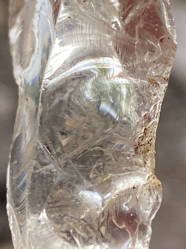 Not a diamond; this specimen exhibits clear conchoidal fracture patterns characteristic of glass, quartz, or slag. - Rough, unpolished, amorphous crystalline or glassy mass with no standard gem shape.