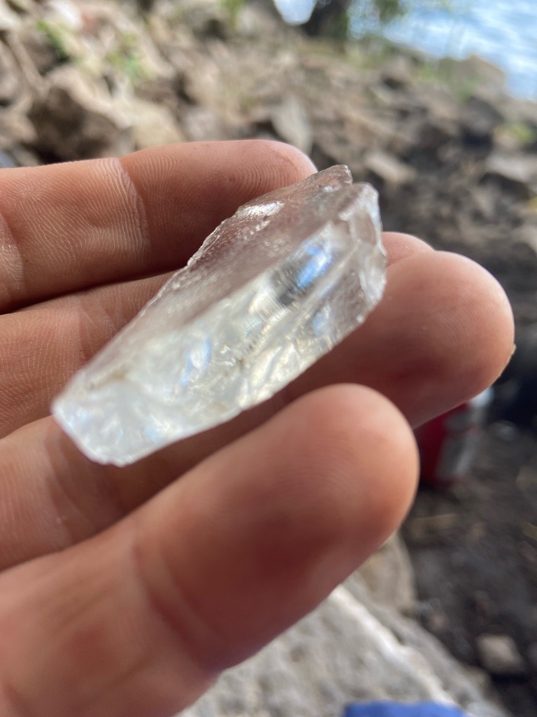 Not a diamond; visual inspection suggests raw quartz or glass/slag fragment. - Rough uncut irregular fragment
