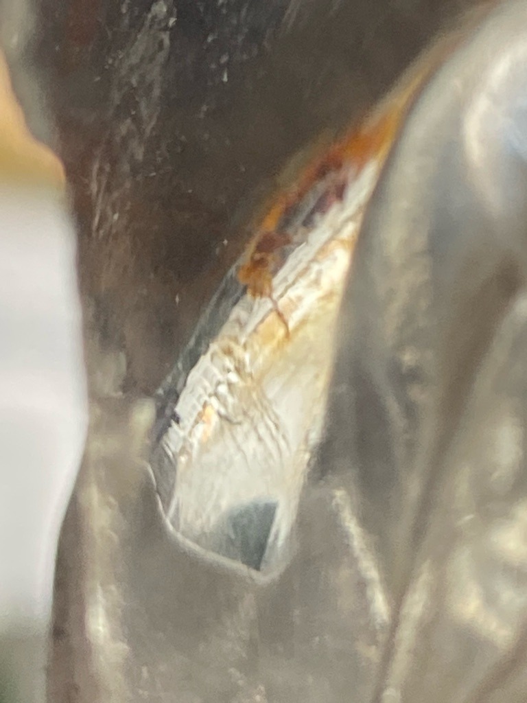 The provided image does not clearly depict a cut or faceted diamond; instead, it shows an obscured, metallic, or irregular reflective surface with possible corrosion or resin, making a definitive diamond type impossible to determine visually. - Indeterminate / Irregular