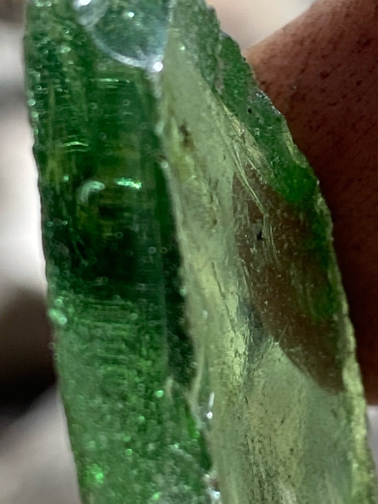 Not a diamond; this specimen is green glass showing characteristic spherical gas bubbles. - Rough/uncut broken chunk with irregular contours.