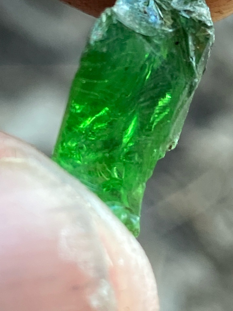 Not a diamond; this is a rough green gemstone crystal, likely tsavorite garnet, emerald, or green tourmaline. - Raw, uncut, or natural crystal form with elongated prismatic habit.