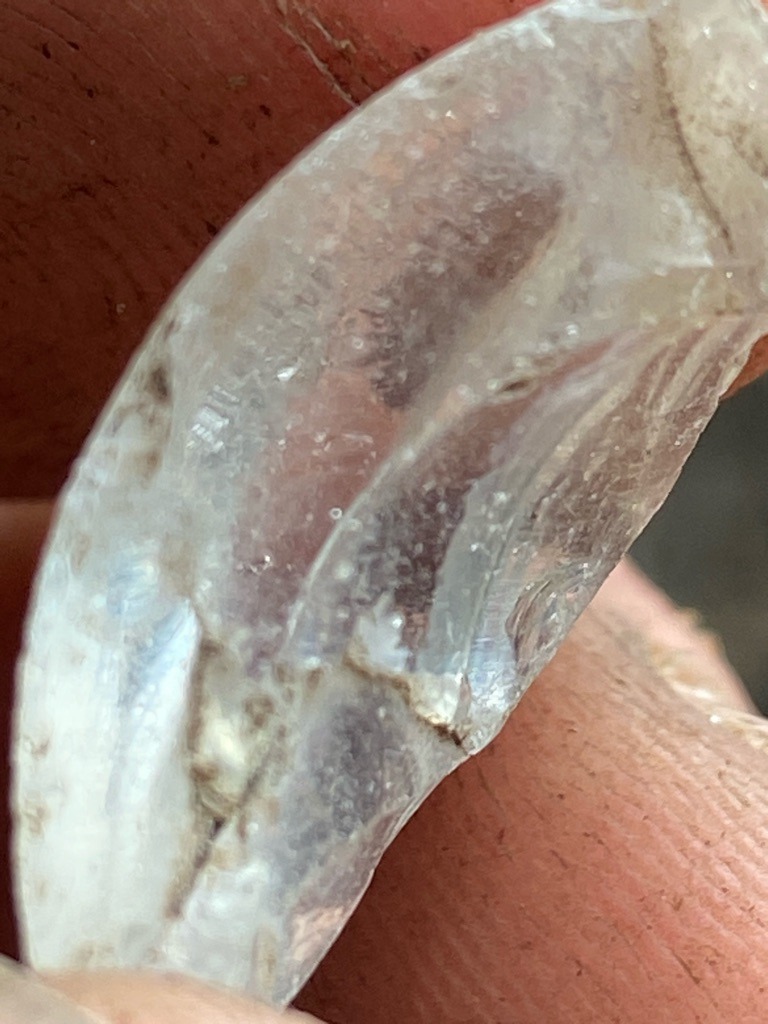 Not a diamond; appears to be quartz, glass, or a similar rough translucent mineral specimen. - Uncut or heavily weathered rough fragment, irregular curved form