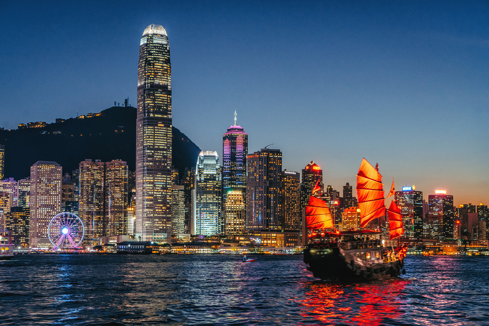 hong kong cityscape and junkboat at twilight