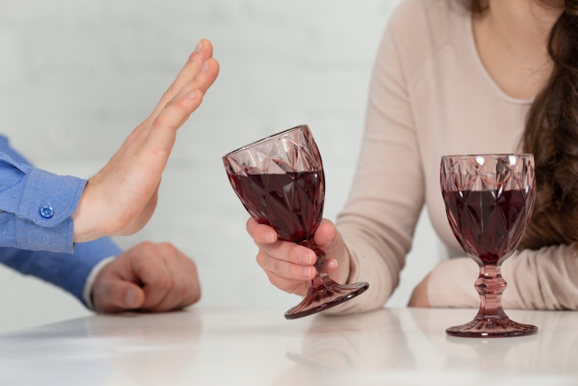 グラスのワインを拒否する男性