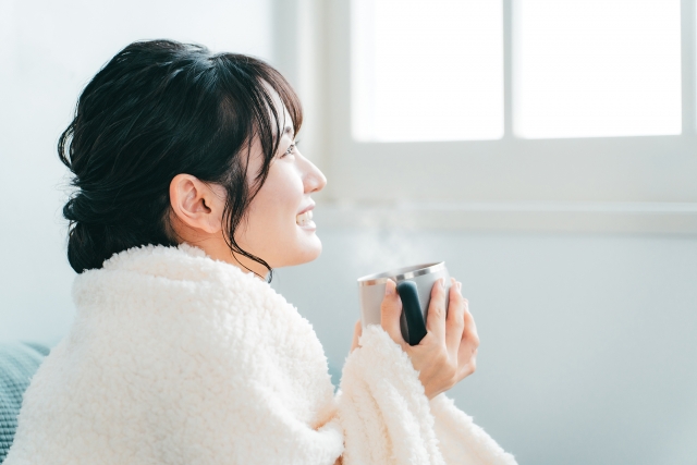 温かい飲み物を手に持つ女性