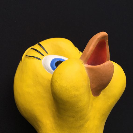 Quetschgelbe Handpuppe Tweety von leicht unten gesehen mit leicht nach oben gerichtetem Scvhnabel, vor schwarzem Hintergrund