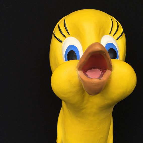 Quietschgelbe Handpuppe Tweety mit aufgerissenem Schnabel vor schwarzem Hintergrund