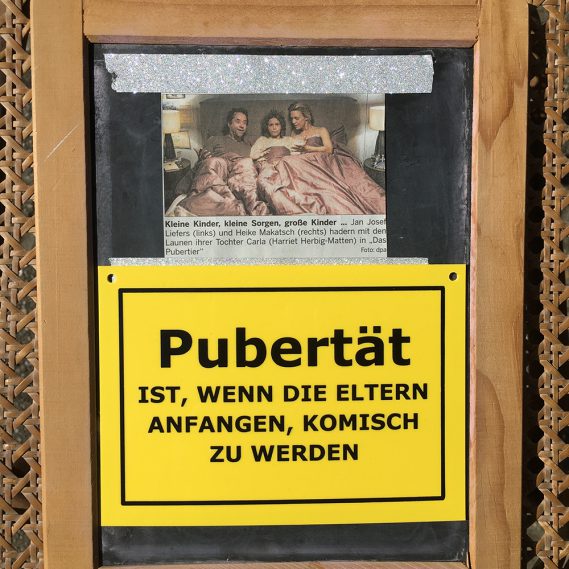 Pubertier Zeitungsausschnitt auf Tafel mit Schild Pubertät