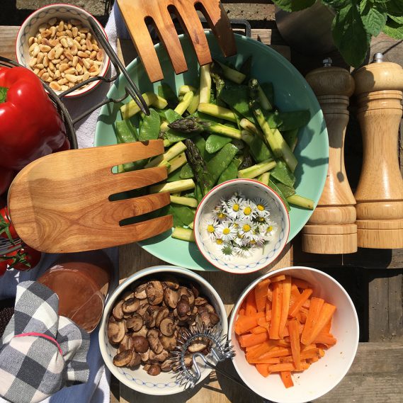 Salatzutaten wie Möhren, Champignons, Spargel, Gänseblümchen von nahem betrachtet