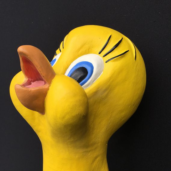 Quietschgelbe Handpuppe Tweety seitlich, den Kopf nach oben gereckt, vor schwarzem Hintergrund