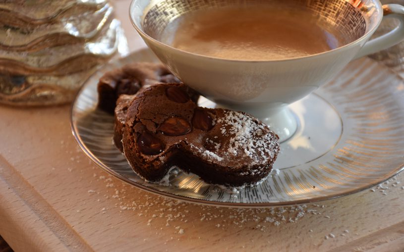 Schöne alte Tasse mit gold, mit Kaffee befüllt, leckere Schokopilzplätzchen auf Unterteller