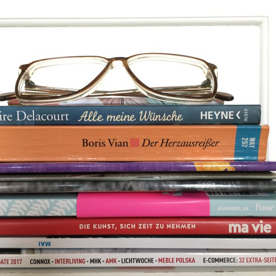 Stapel Bücher und Zeitschriften mit Brille